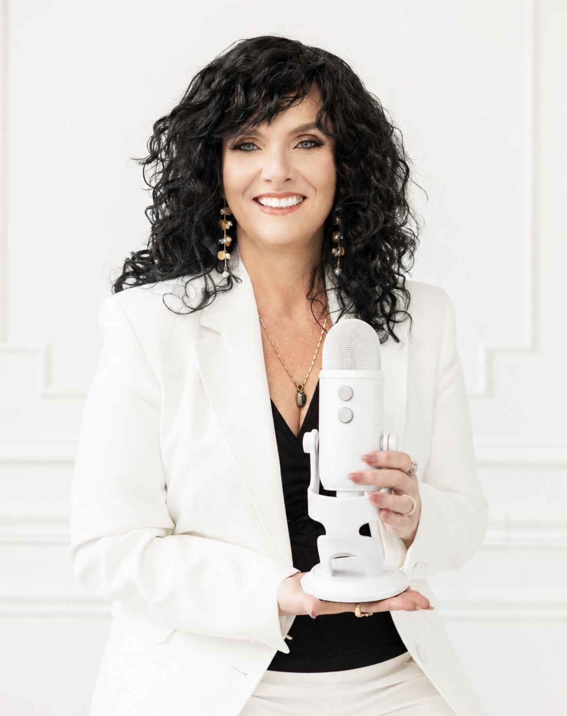 Kathy Tropiano, en tailleur blanc, tenant un microphone